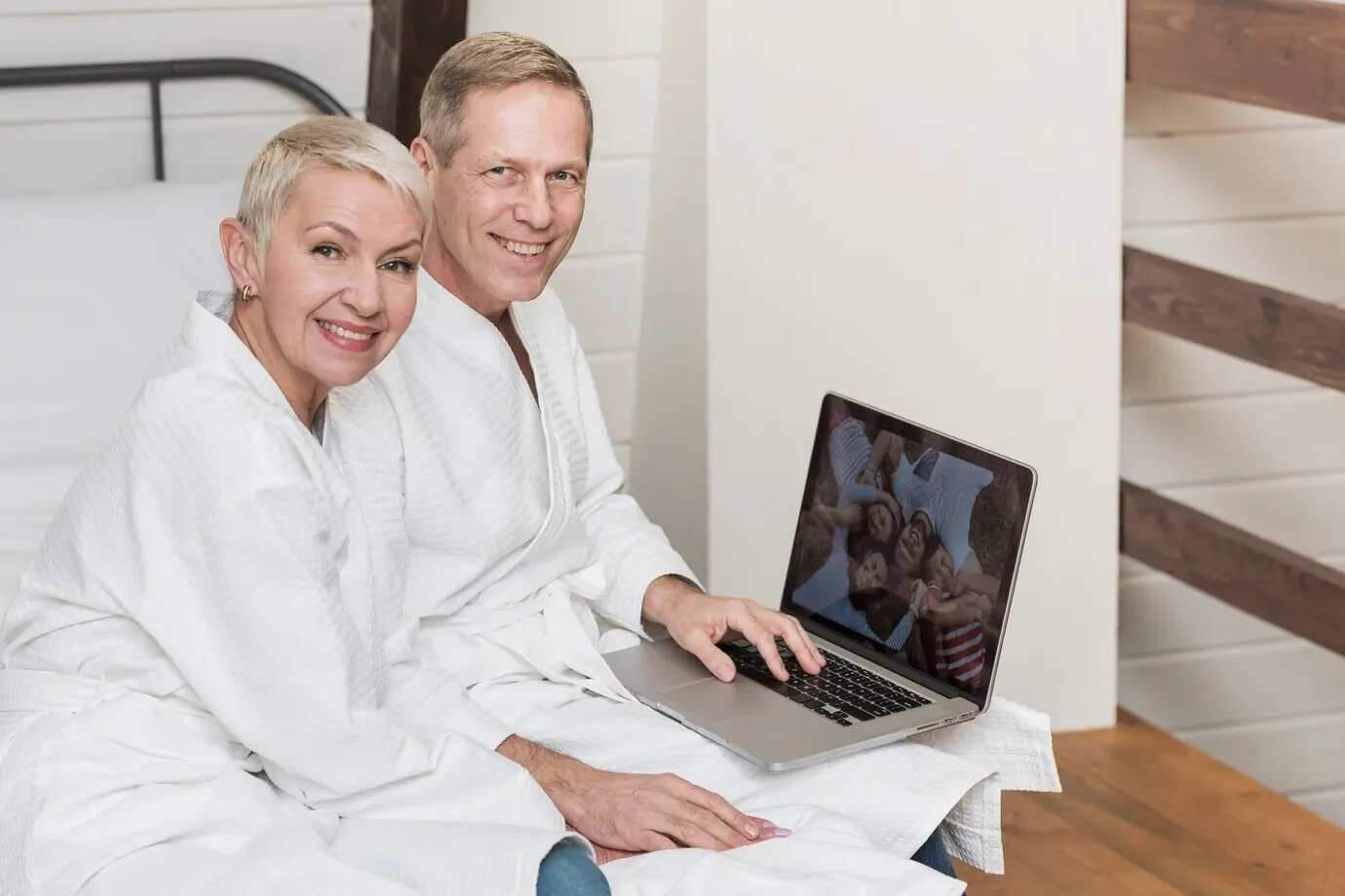 Ein älteres Paar schaut sich zu Hause gemeinsam Fotos auf ihrem Laptop an.